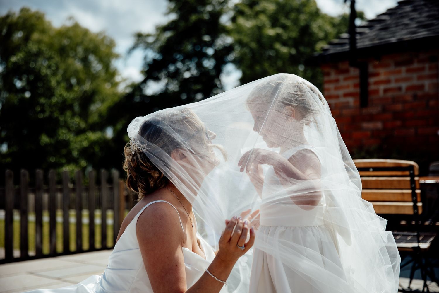 Wedding veil flows dramatically in breeze during outdoor photo session.
