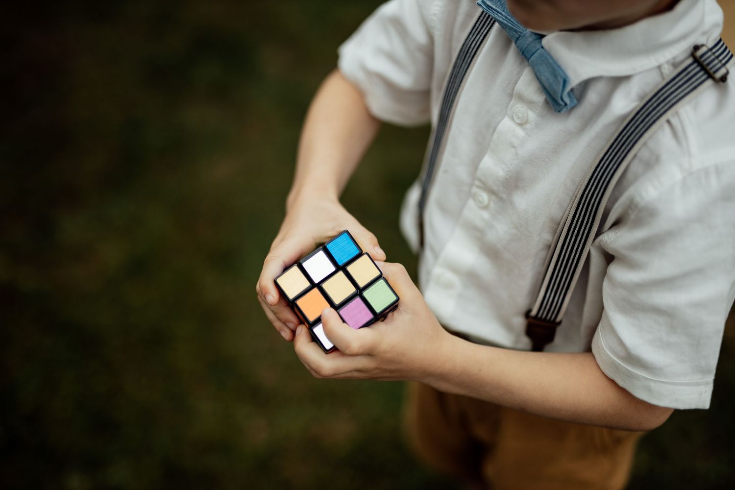 Person holding a colorful Rubik's cube puzzle during casual outdoor moment.