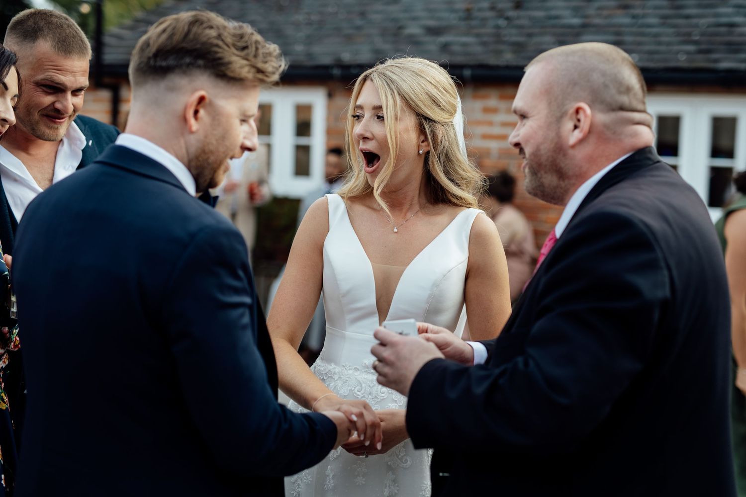 Candid moments between wedding party members during outdoor celebration.