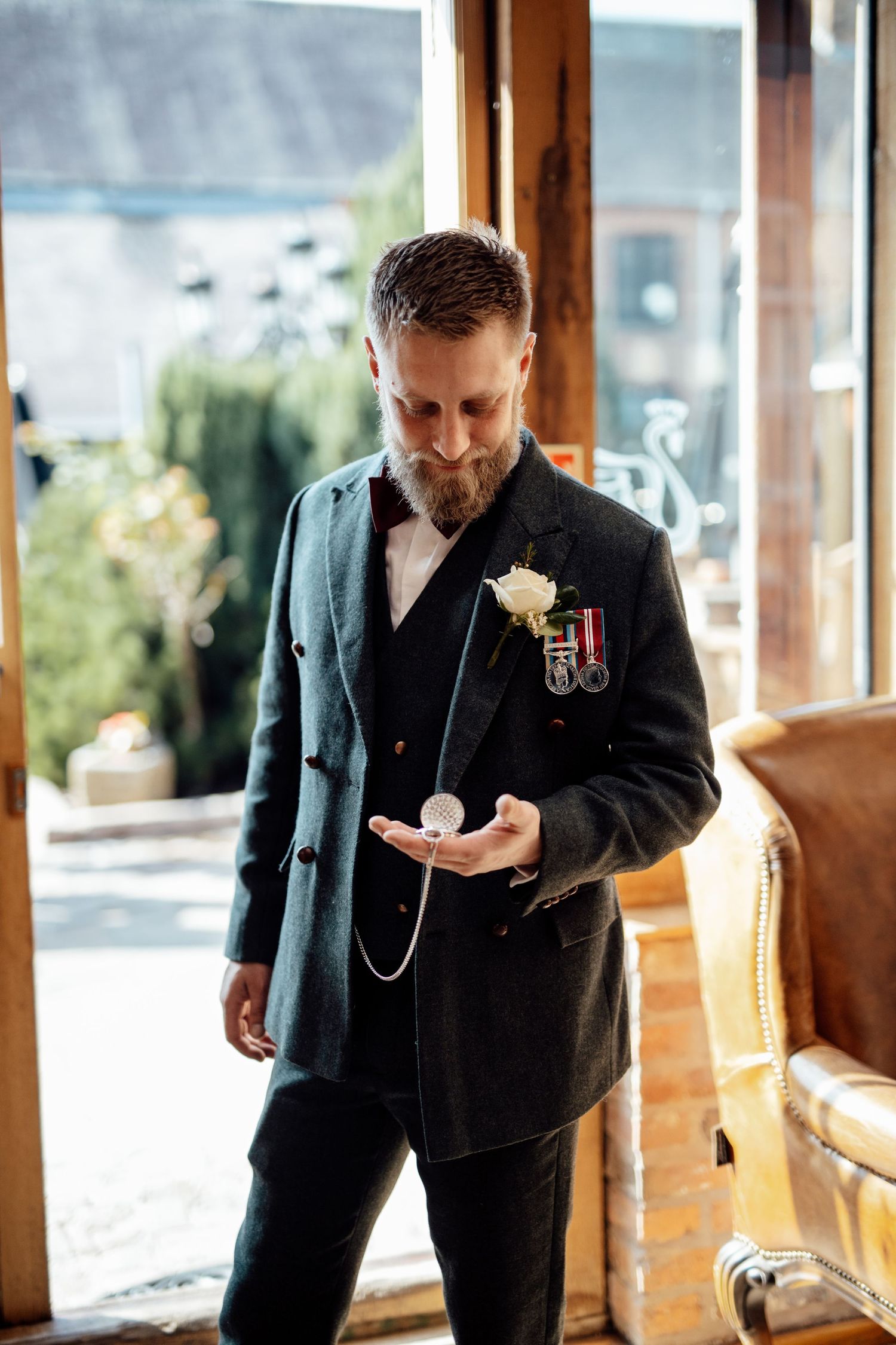 Groomsmen checking pocket watches while getting ready in formal attire.