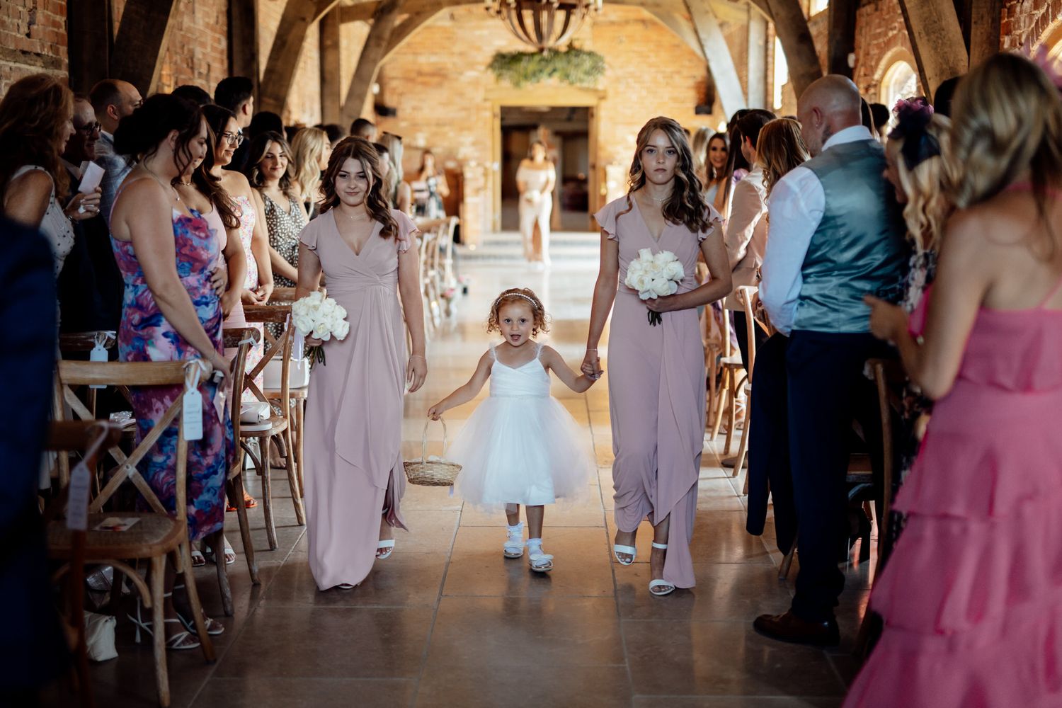 Wedding reception scene in rustic brick venue with guests mingling and dancing.