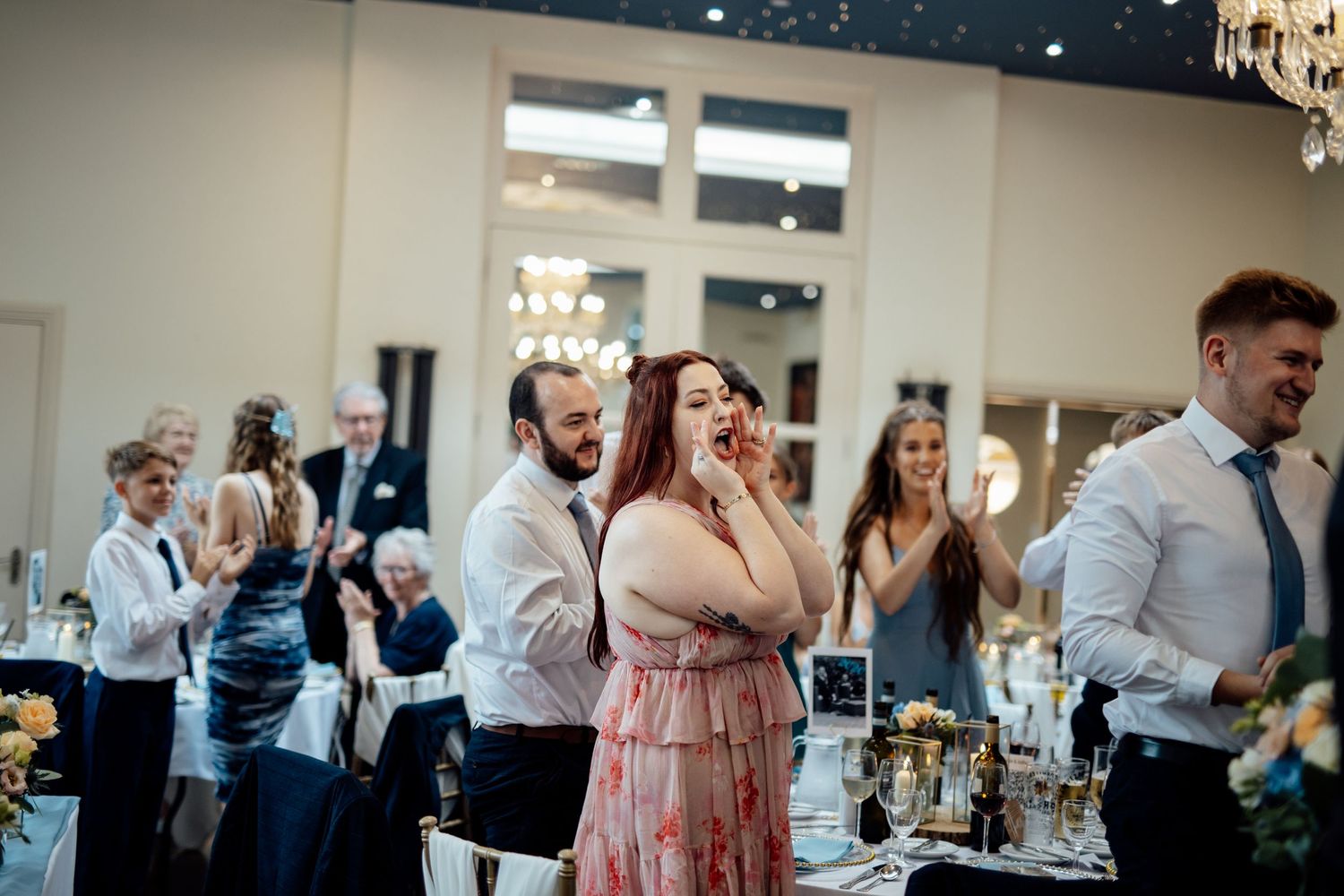 Wedding reception guests share emotional reactions during celebration.