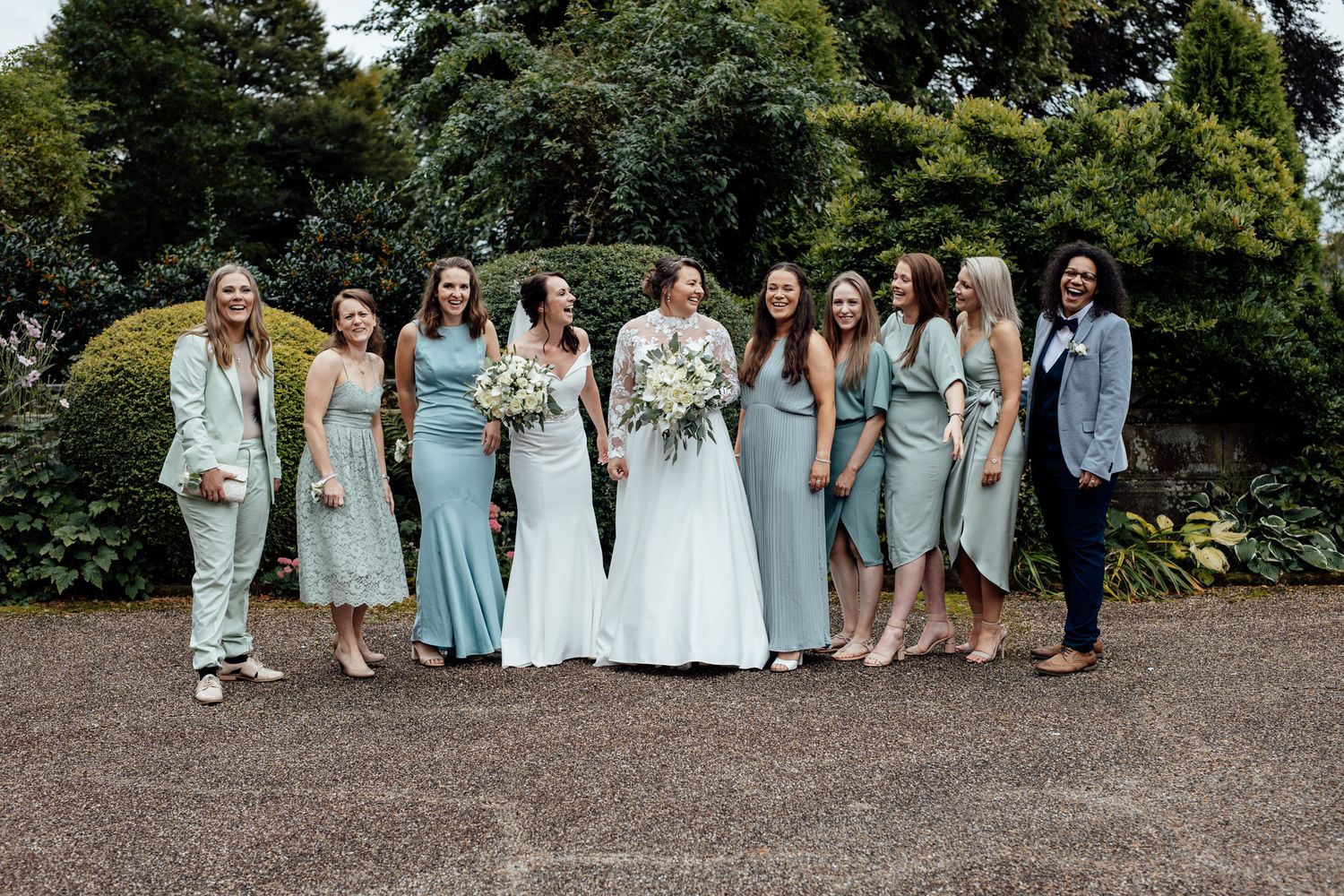 Wedding party in coordinated blue and white dresses posing outdoors.