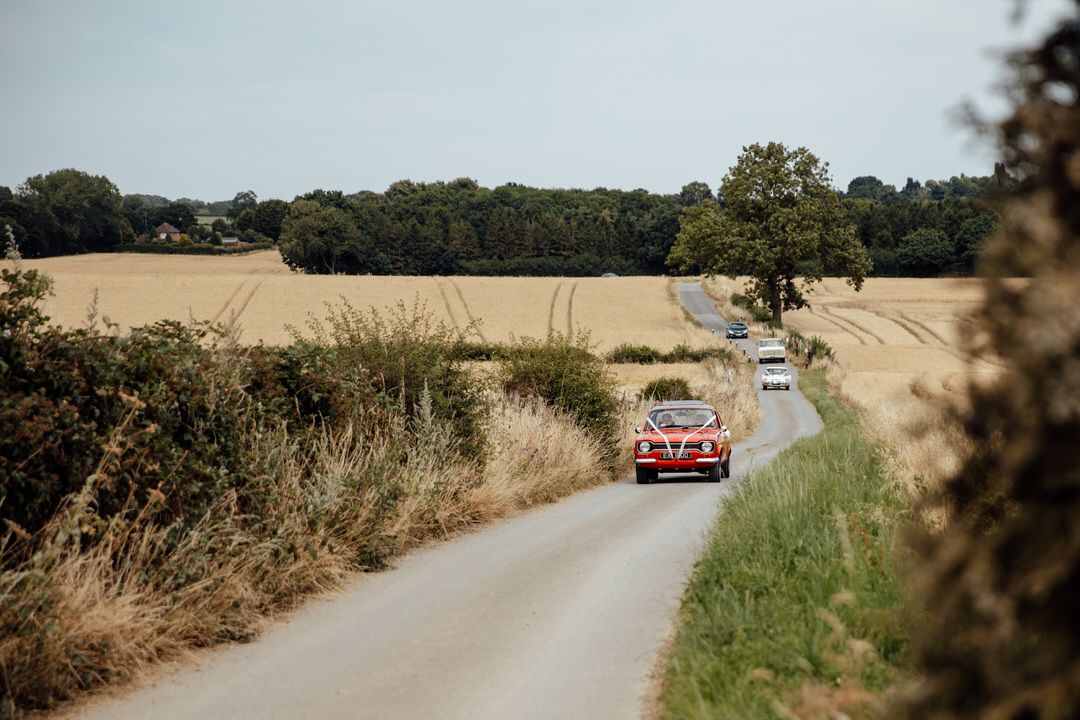 A winding country road through golden wheat fields on a summer day.