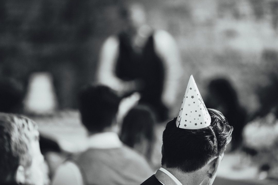 Black and white panorama of wedding guests mingling during a reception celebration.