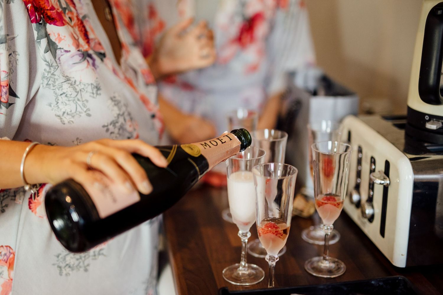 Wedding morning preparations with champagne glasses and details on wooden table.