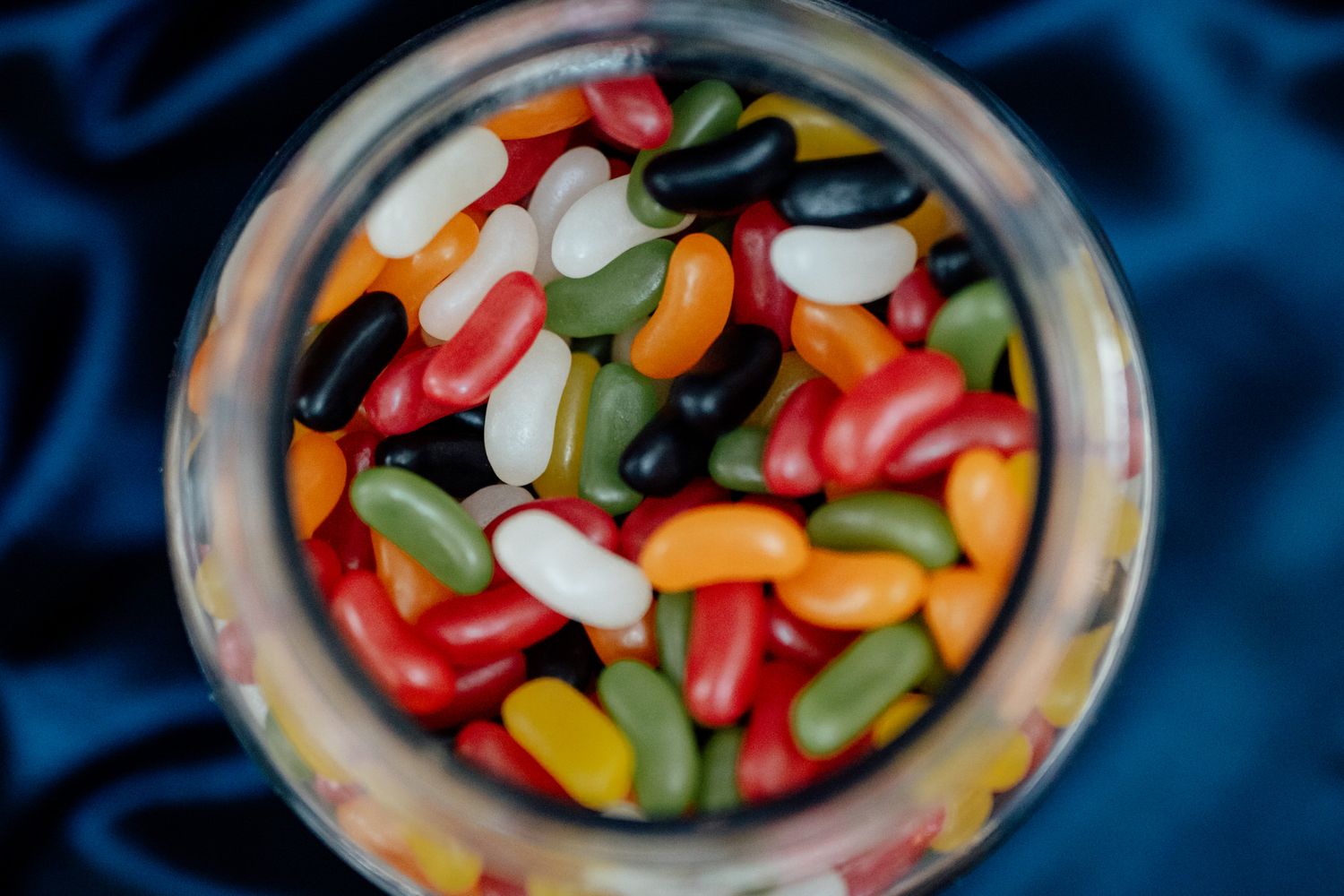 Colorful jelly beans and candies displayed in glass bowls at a wedding reception.