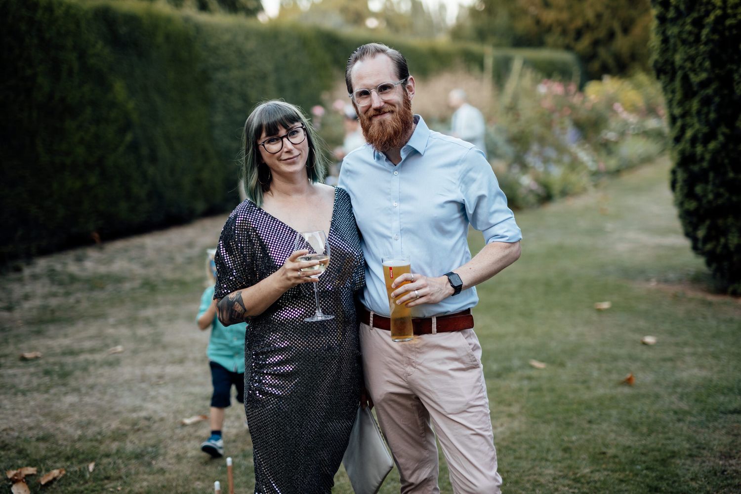 Wedding guests mingling on a grassy lawn during outdoor reception.