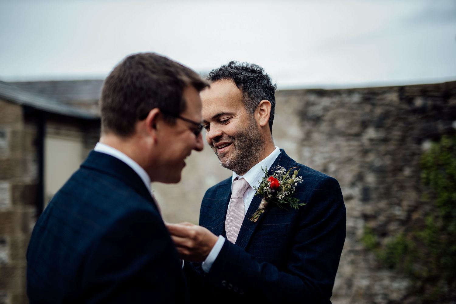 Two people sharing an intimate moment against a stone wall background.