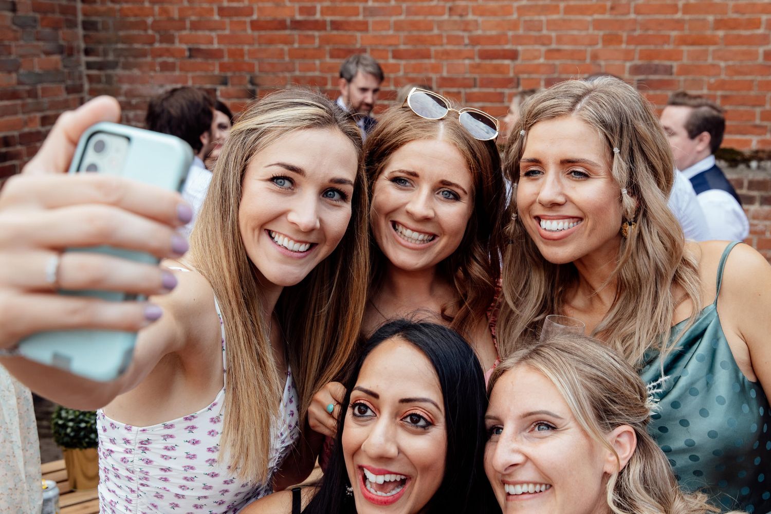 Group of wedding guests smiling and celebrating together at reception.