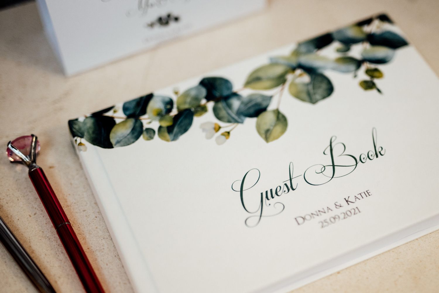 Elegant wedding stationery with eucalyptus leaves and calligraphy details.