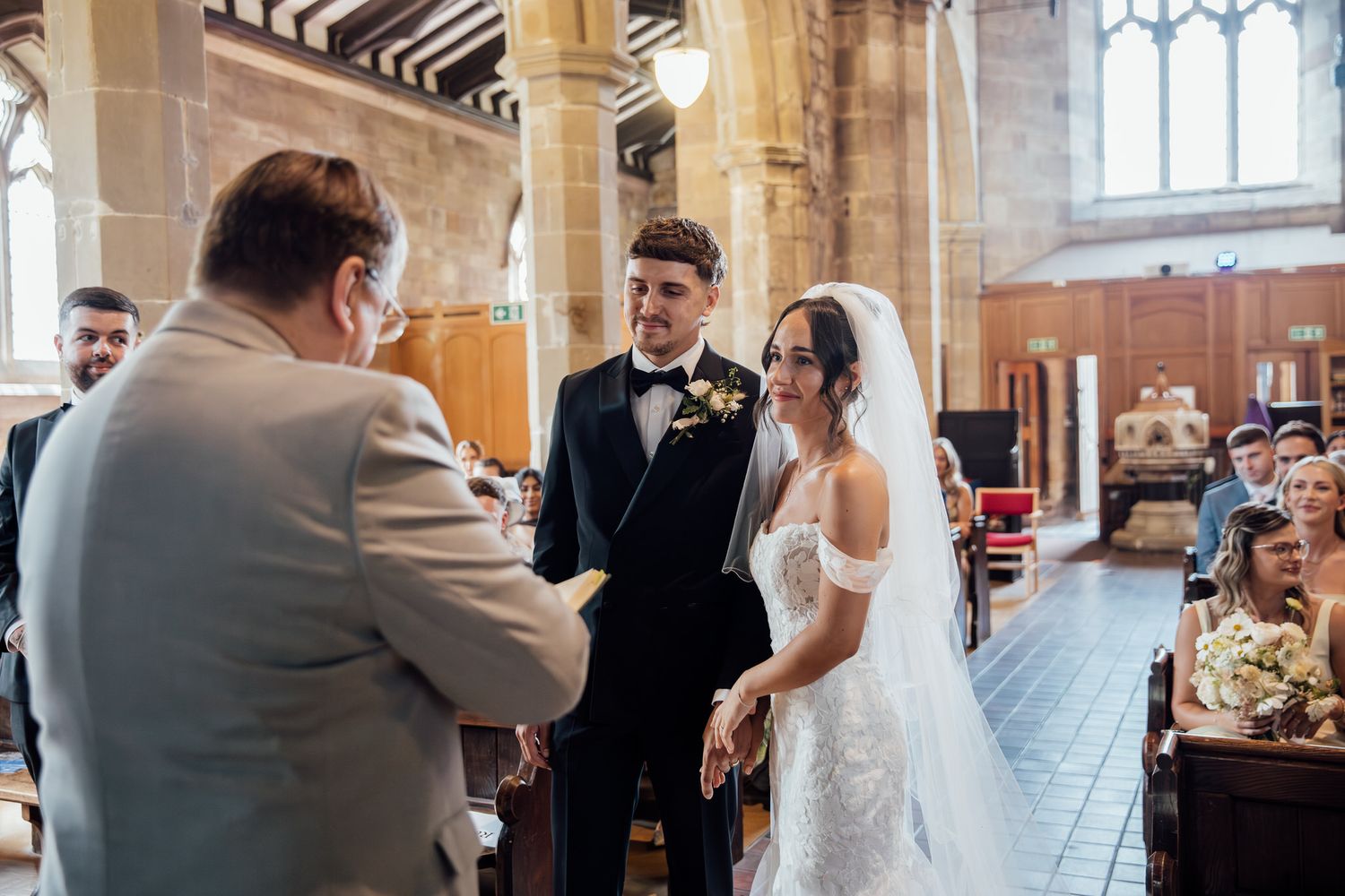 Wedding ceremony in a historic church with beautiful stone architecture and stained glass windows.