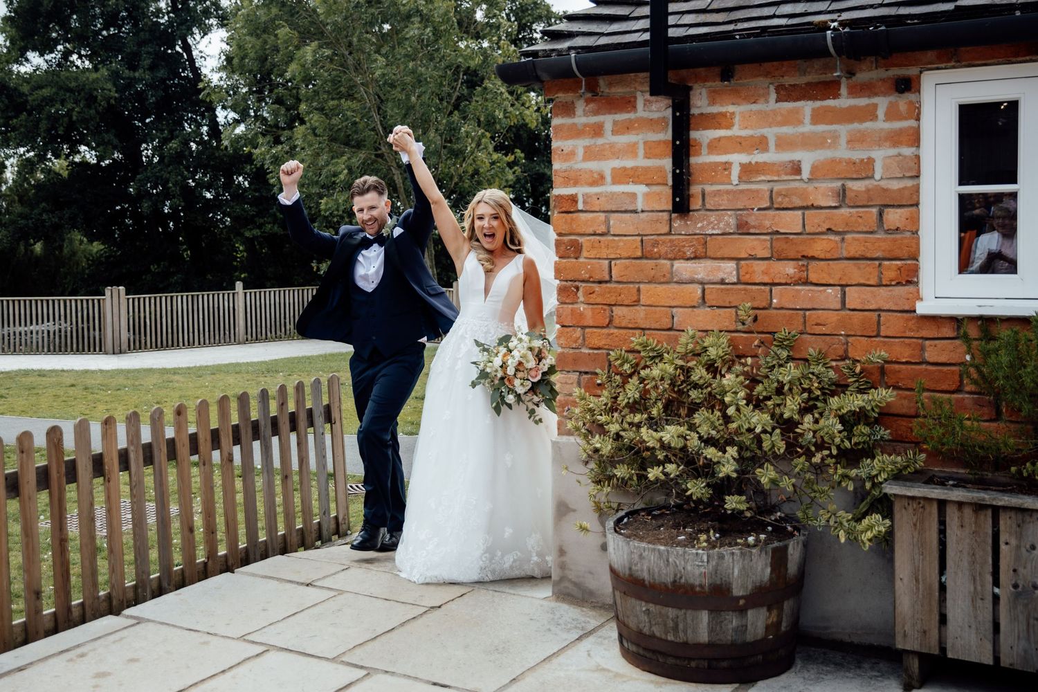 Elegant outdoor wedding venue with brick walls and rustic wooden barrels creating a charming atmosphere.