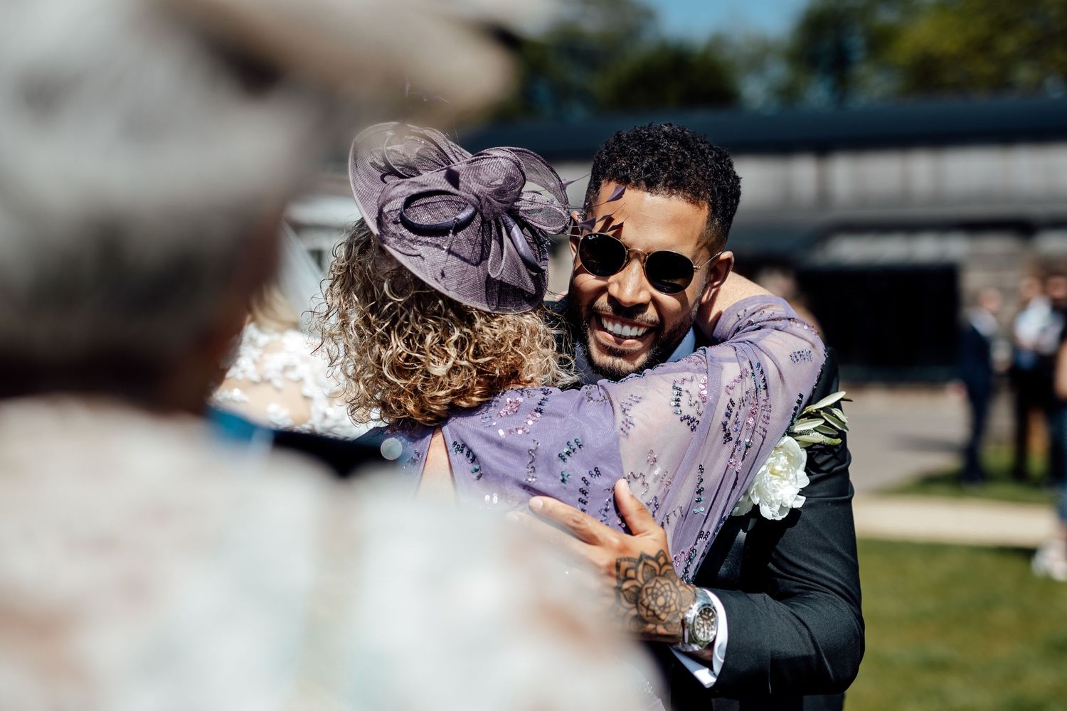 Wedding party celebrates joyfully with confetti and laughter in an outdoor garden setting.