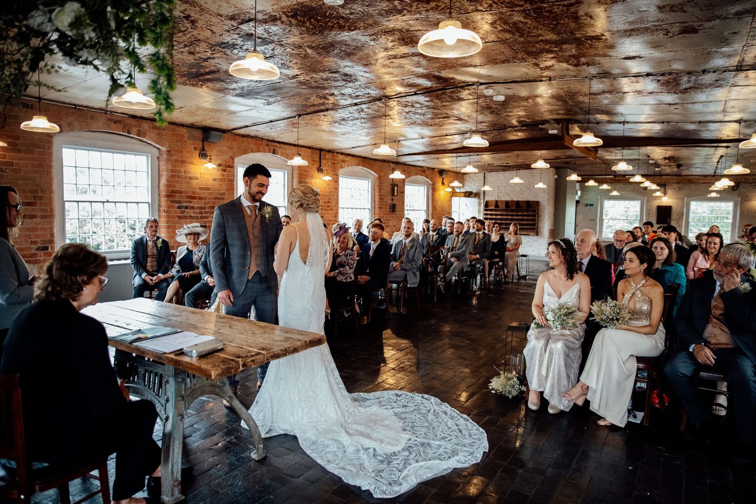 Rustic wedding venue interior with exposed brick walls and wooden beams.