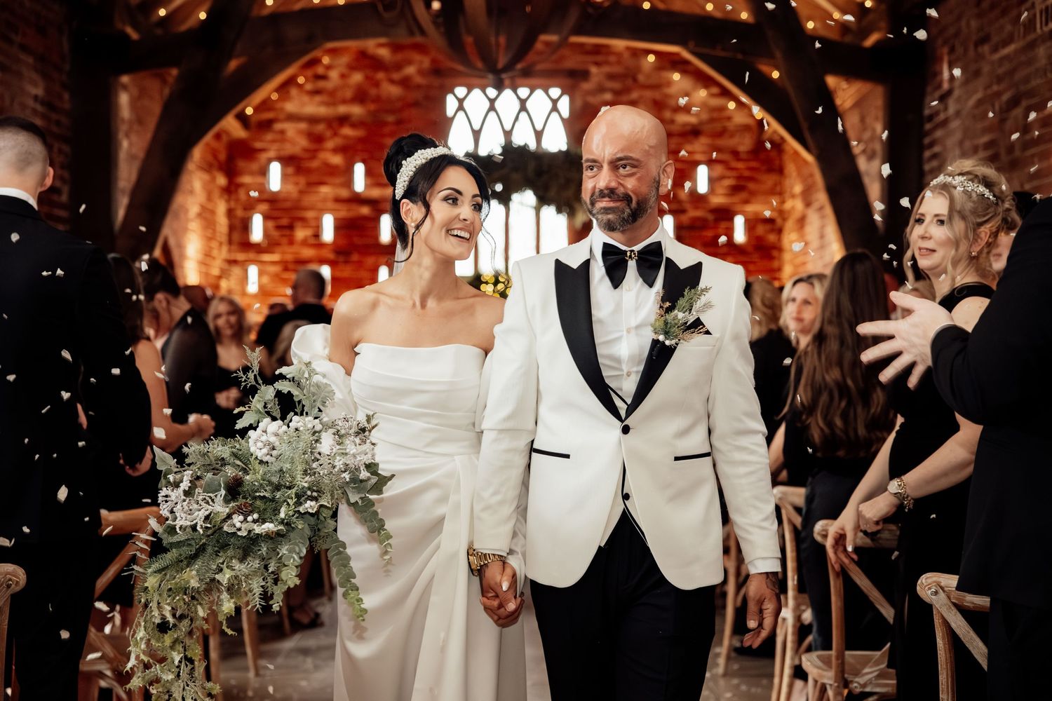 Celebration under arched brick ceiling with festive lighting.
