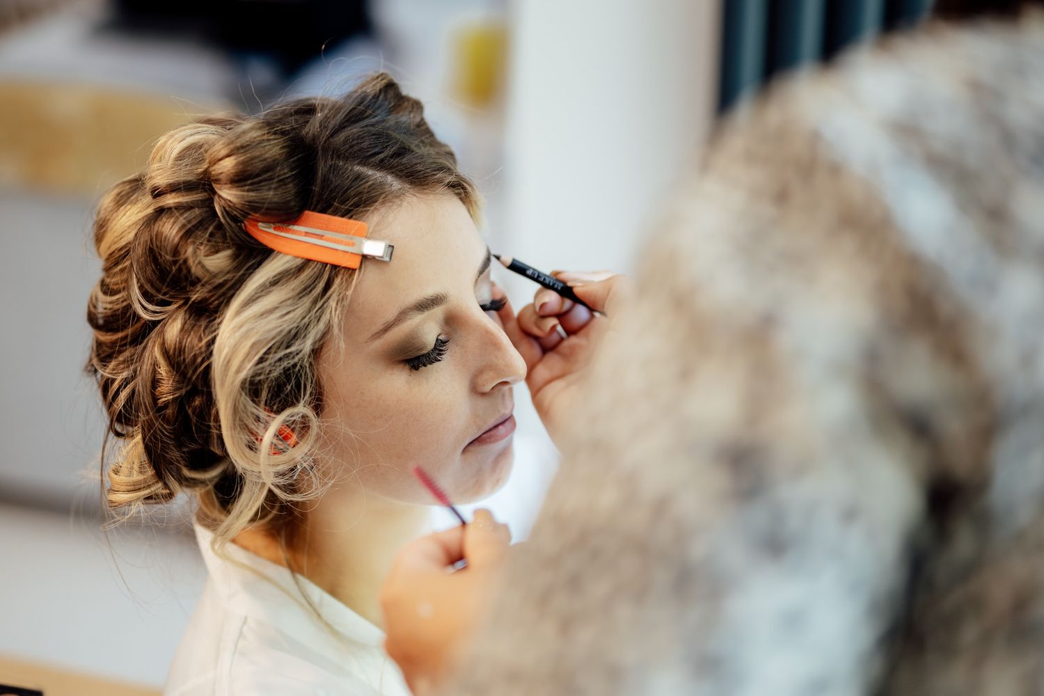 Elegant bridal preparation with soft, natural lighting and delicate styling details.