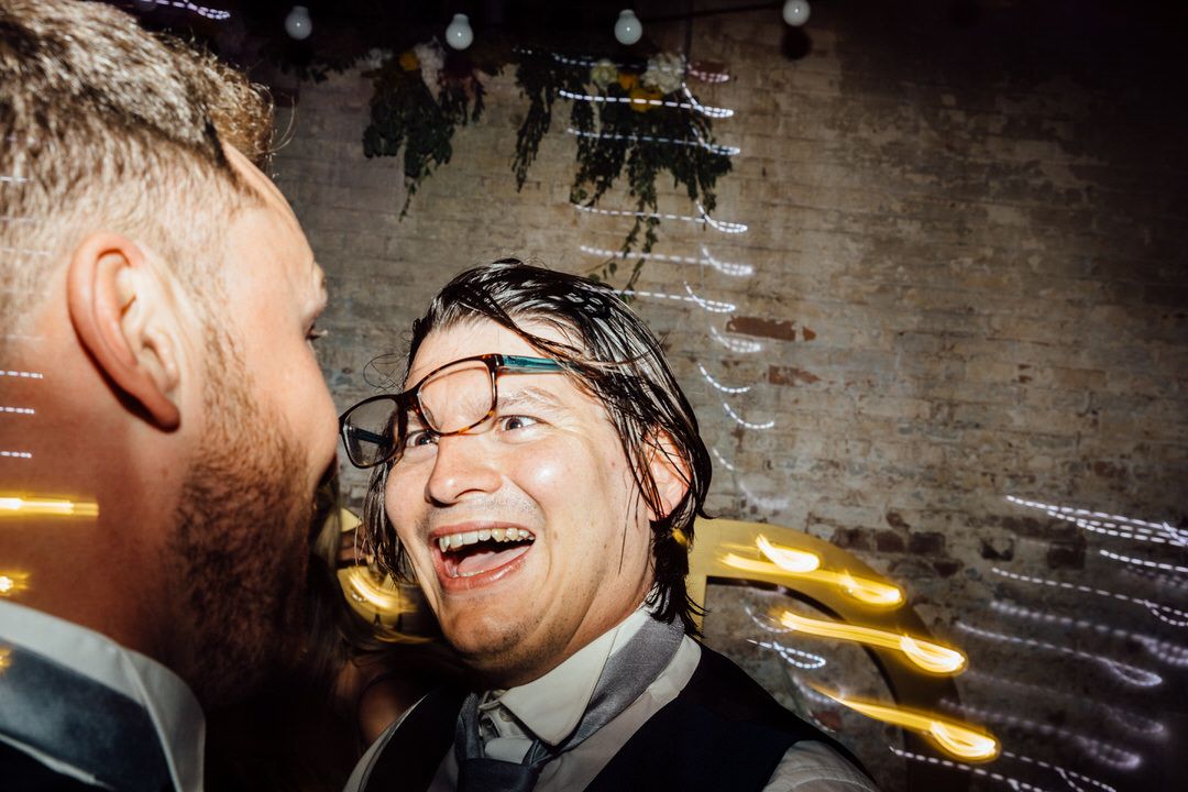 Candid black and white shots of wedding guests laughing during reception.