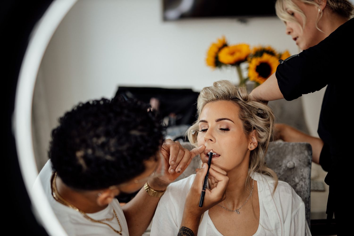 Wedding morning preparation scene with makeup application and candid moments.