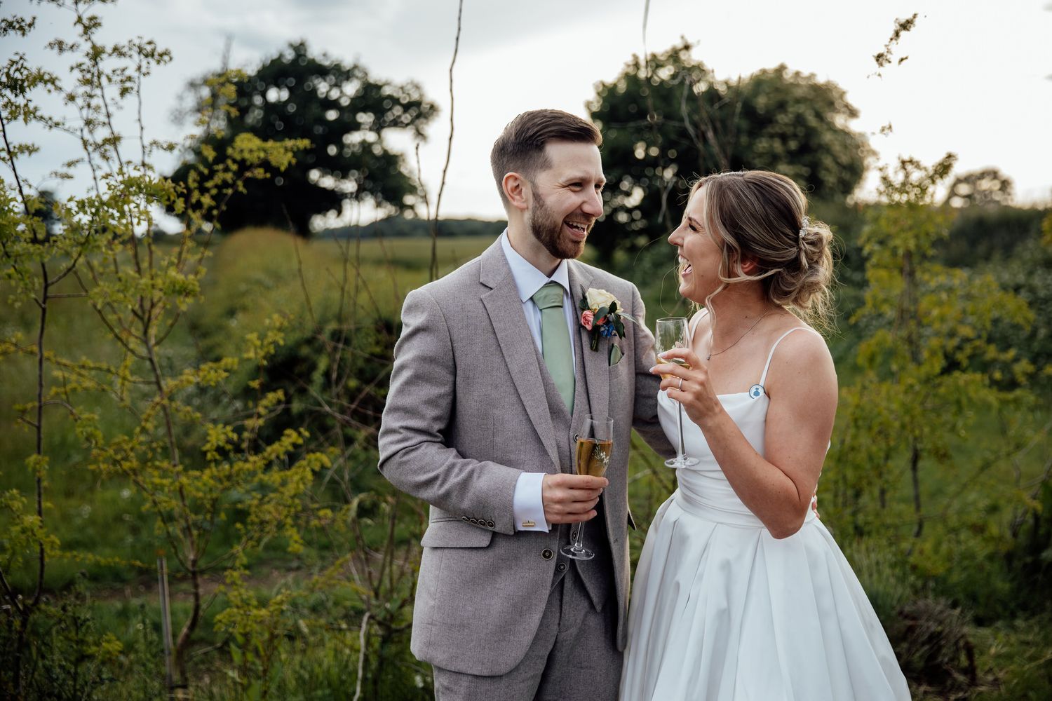 Couple sharing a romantic moment outdoors in a garden setting during their wedding day.