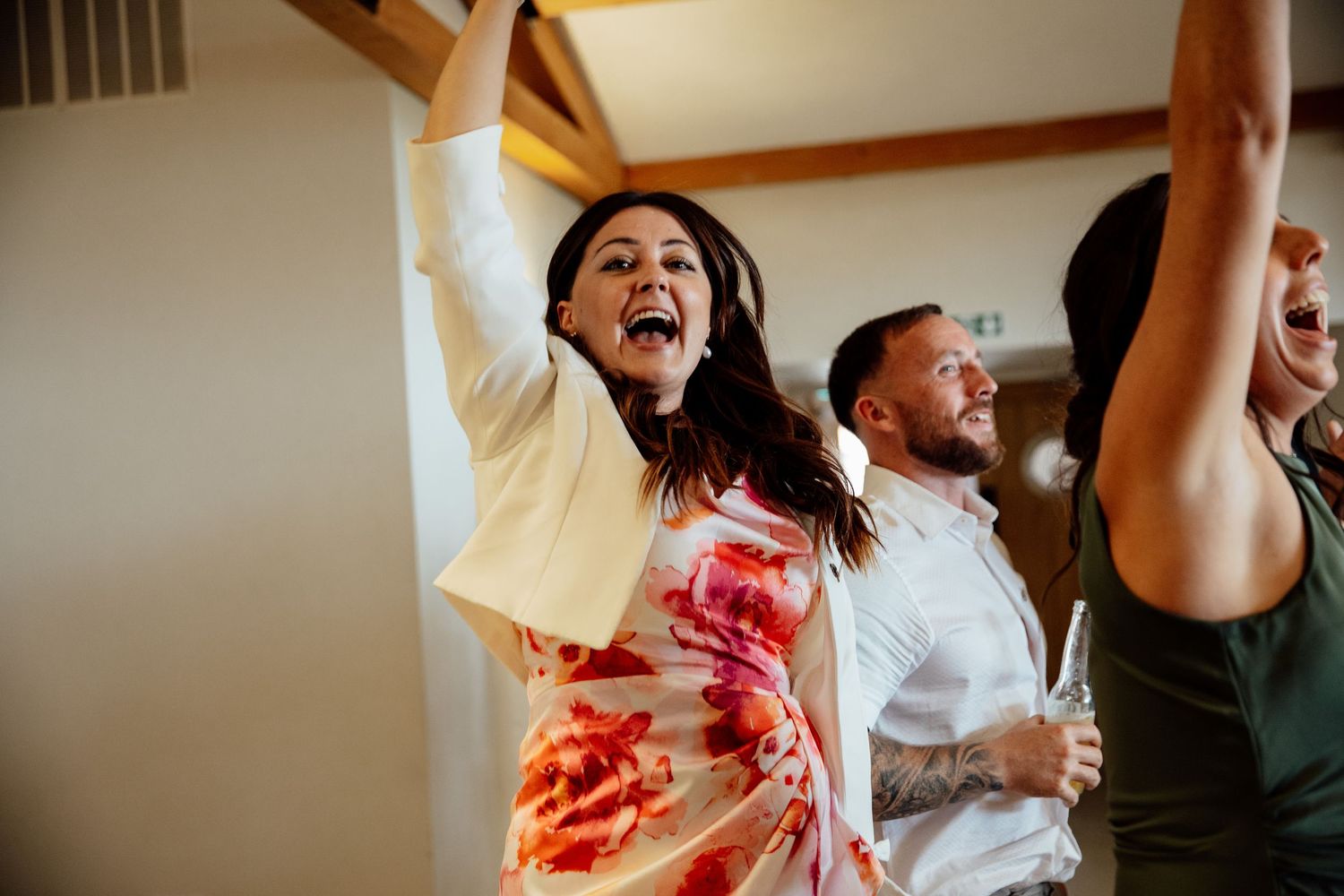 Wedding guests celebrating enthusiastically during reception party.