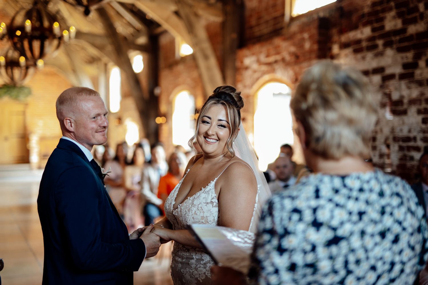 Wedding ceremony moments in a rustic brick venue with natural lighting.