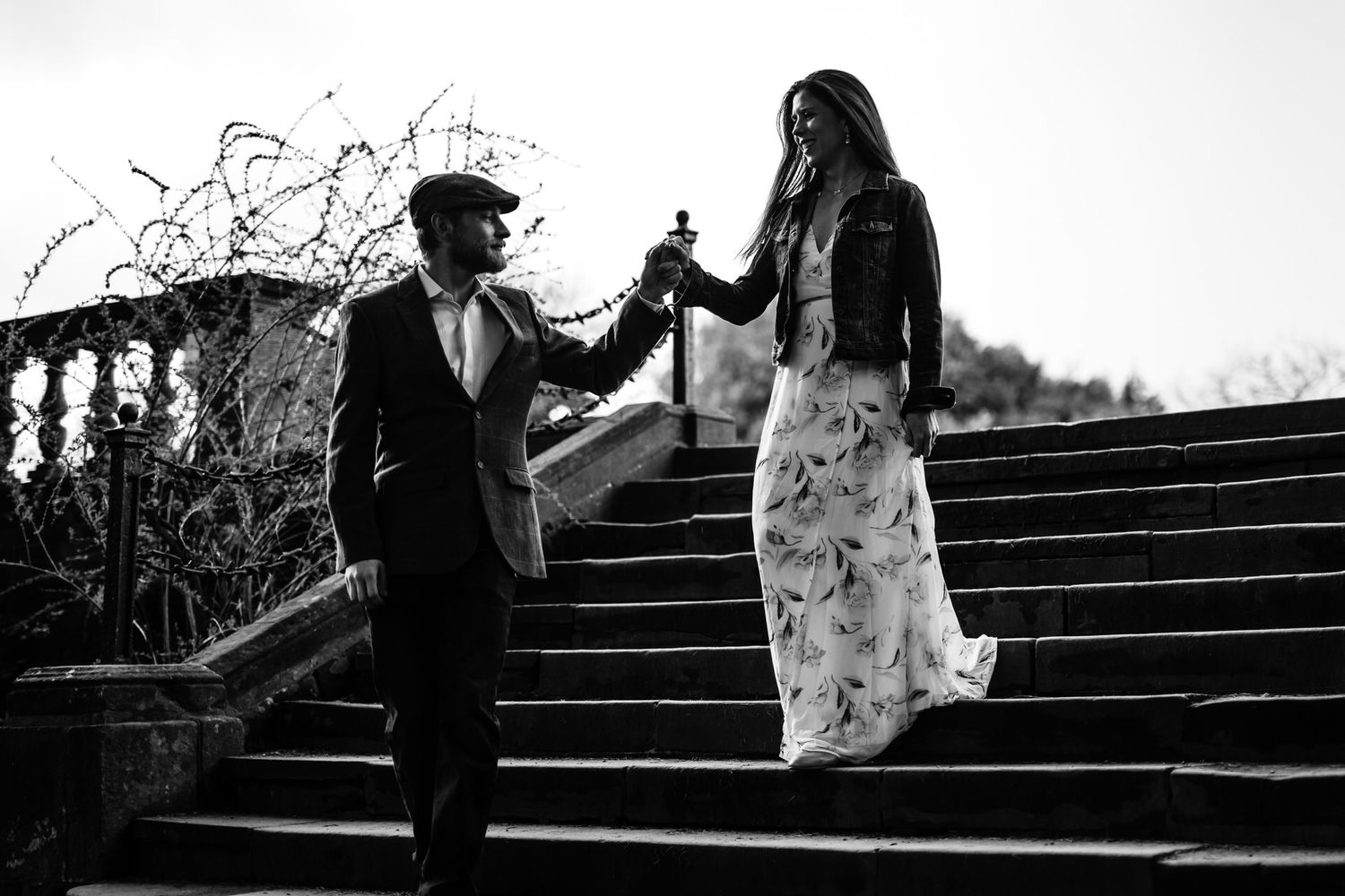 Couple posing on outdoor stone steps during engagement session.