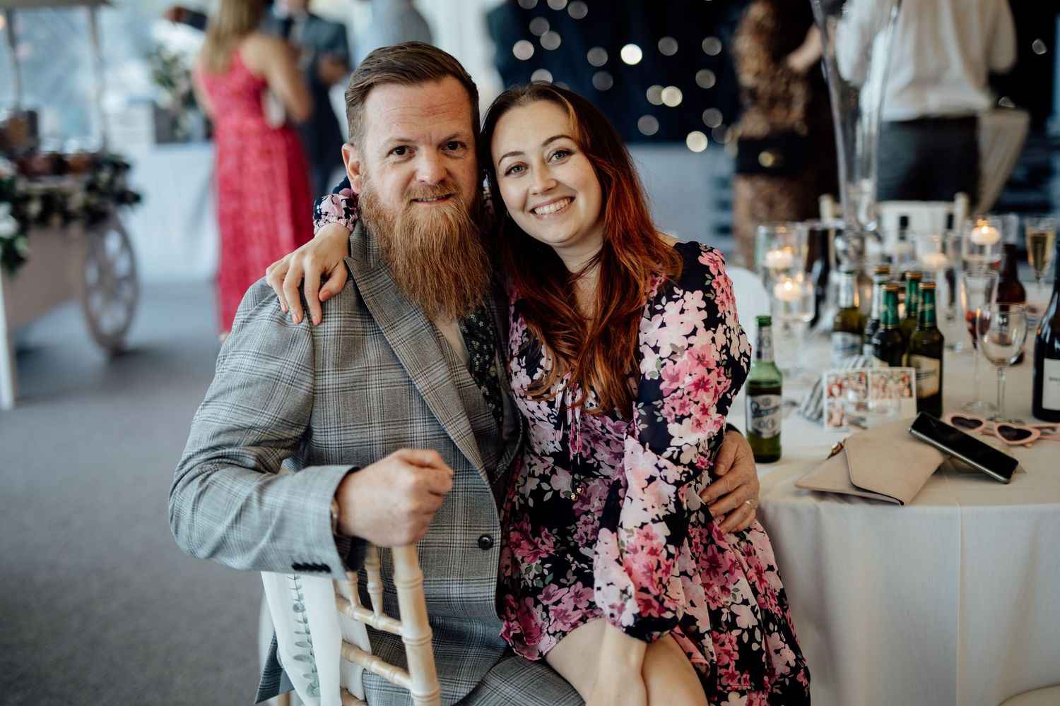 Wedding guests enjoying themselves at a reception with festive lighting and table settings.