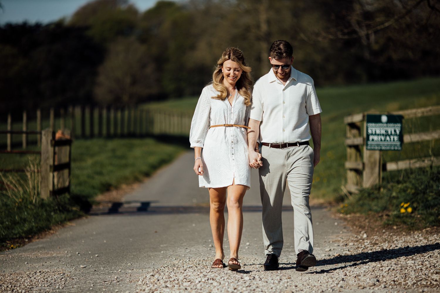 Couple strolling together on gravel path through scenic park grounds.