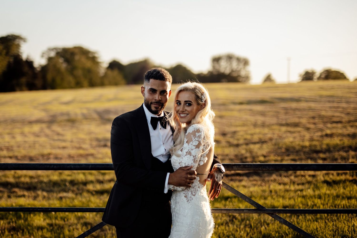 Couple poses in golden hour sunlight on their wedding day.
