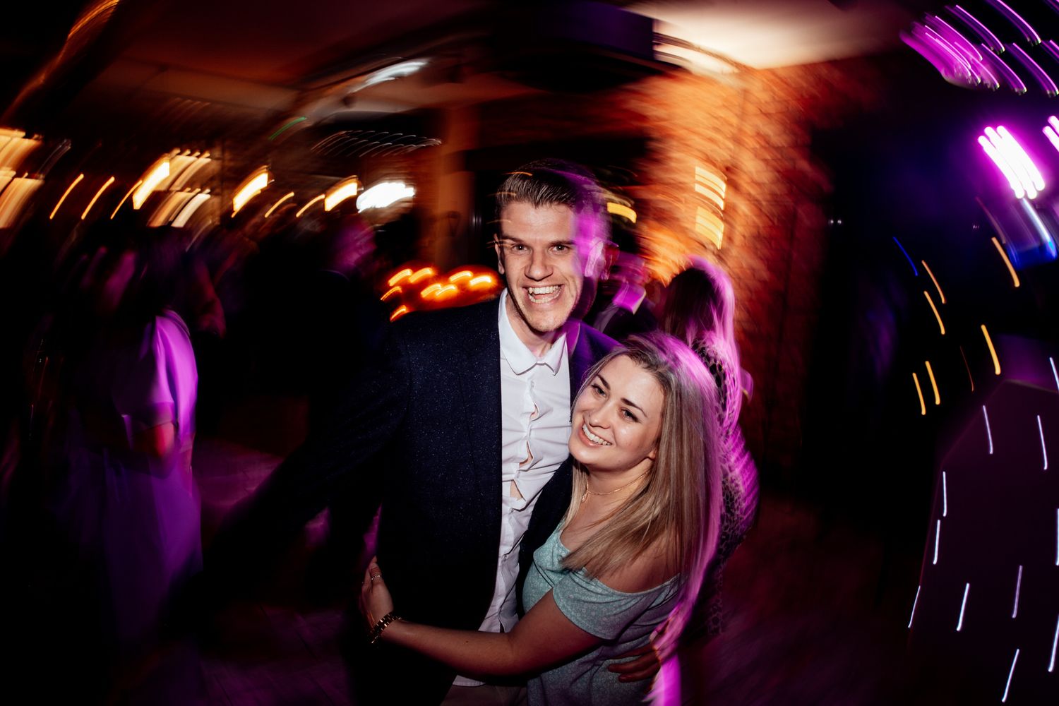 Dynamic nightclub photo with colorful lighting and motion blur effects.