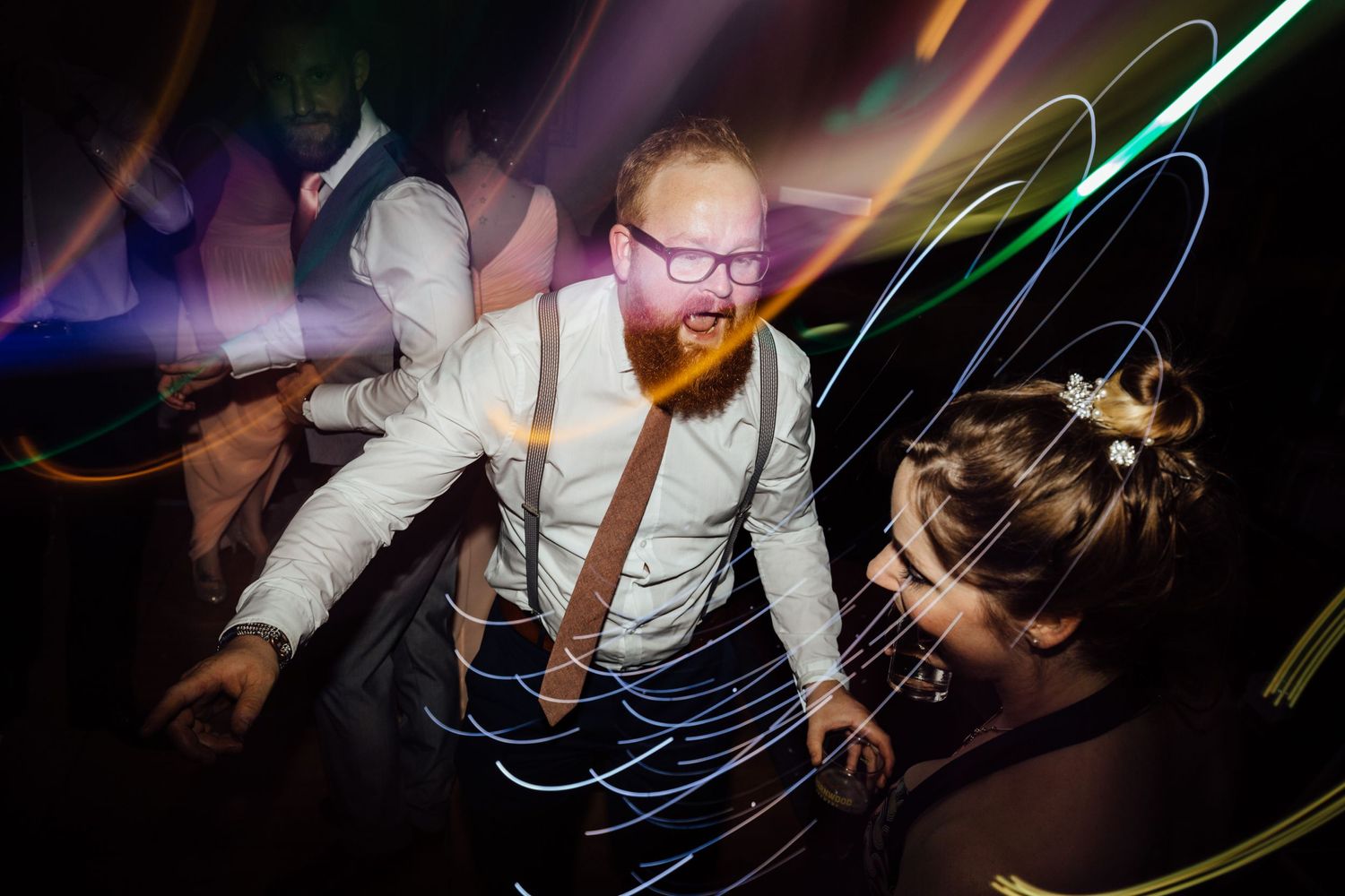 Dance floor celebration with colorful light trails and motion blur effects.