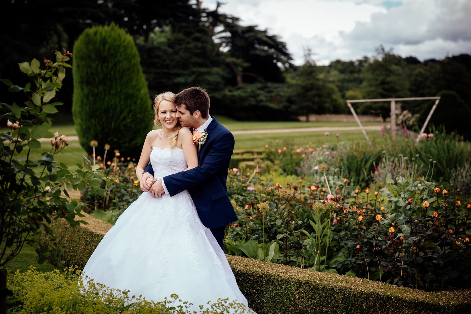 Romantic couple portraits in blooming garden with white wedding dress.