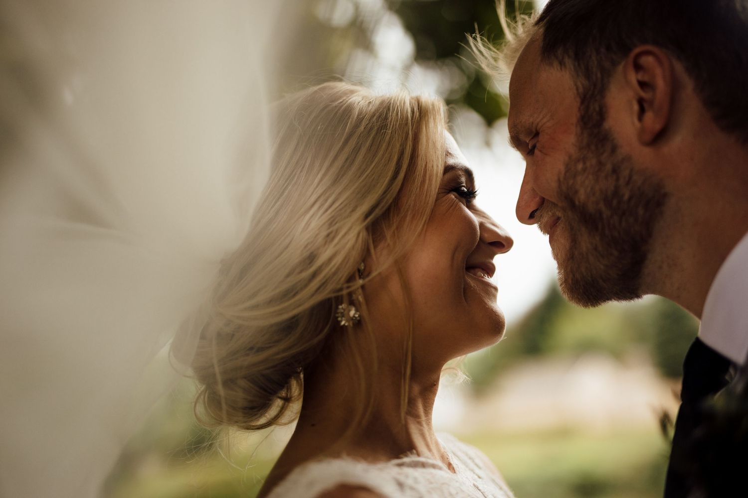 Romantic close-up moment between bride and groom in natural lighting.