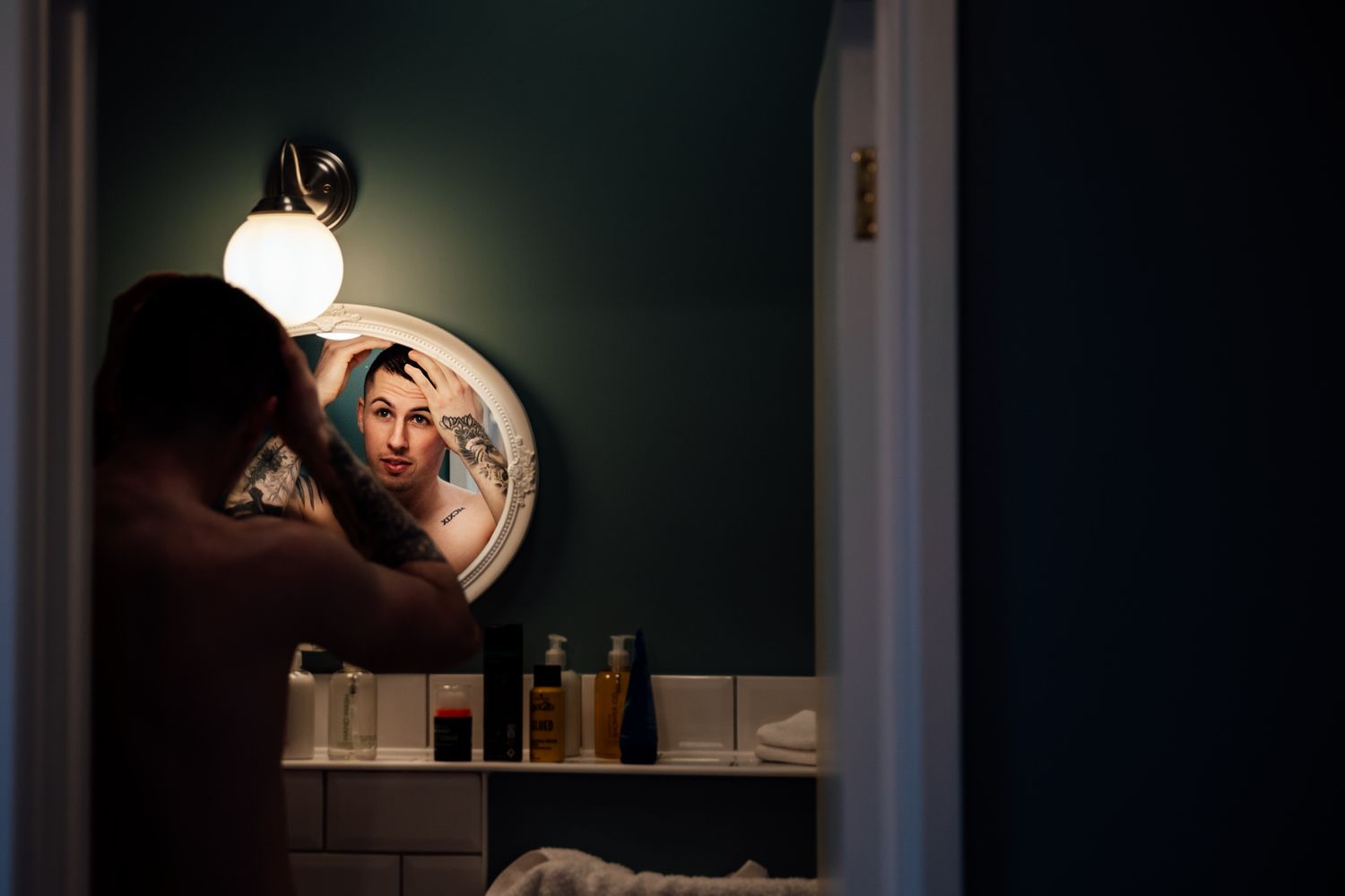 Dramatic low-light wedding photography composition through vintage mirror frames.