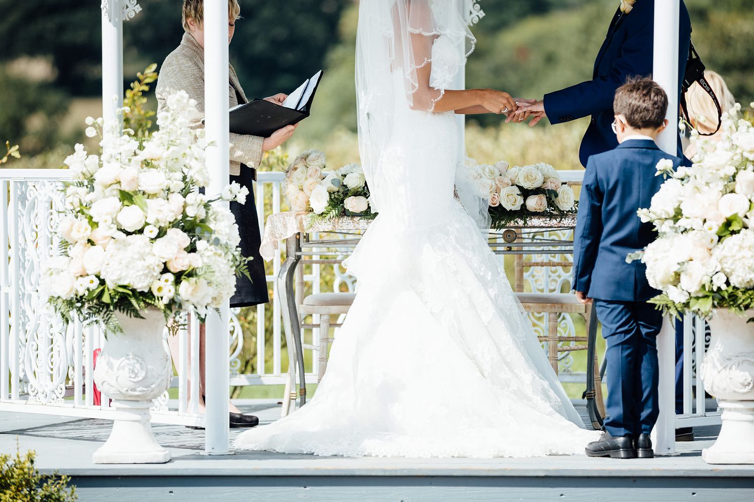 Elegant wedding ceremony setup with white floral arrangements and decorative details.