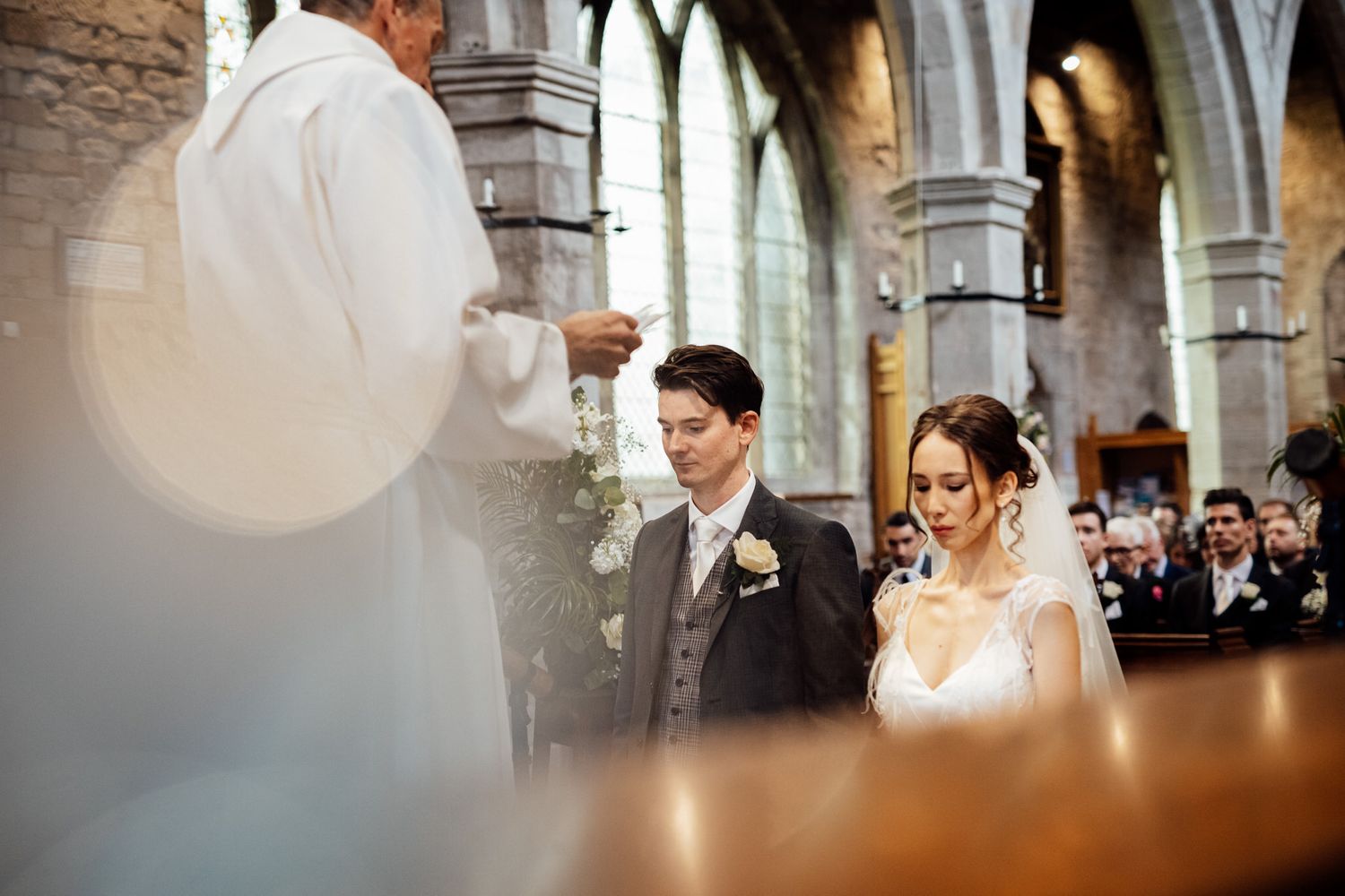 Intimate wedding moments captured inside a historic church with stone columns and natural light.