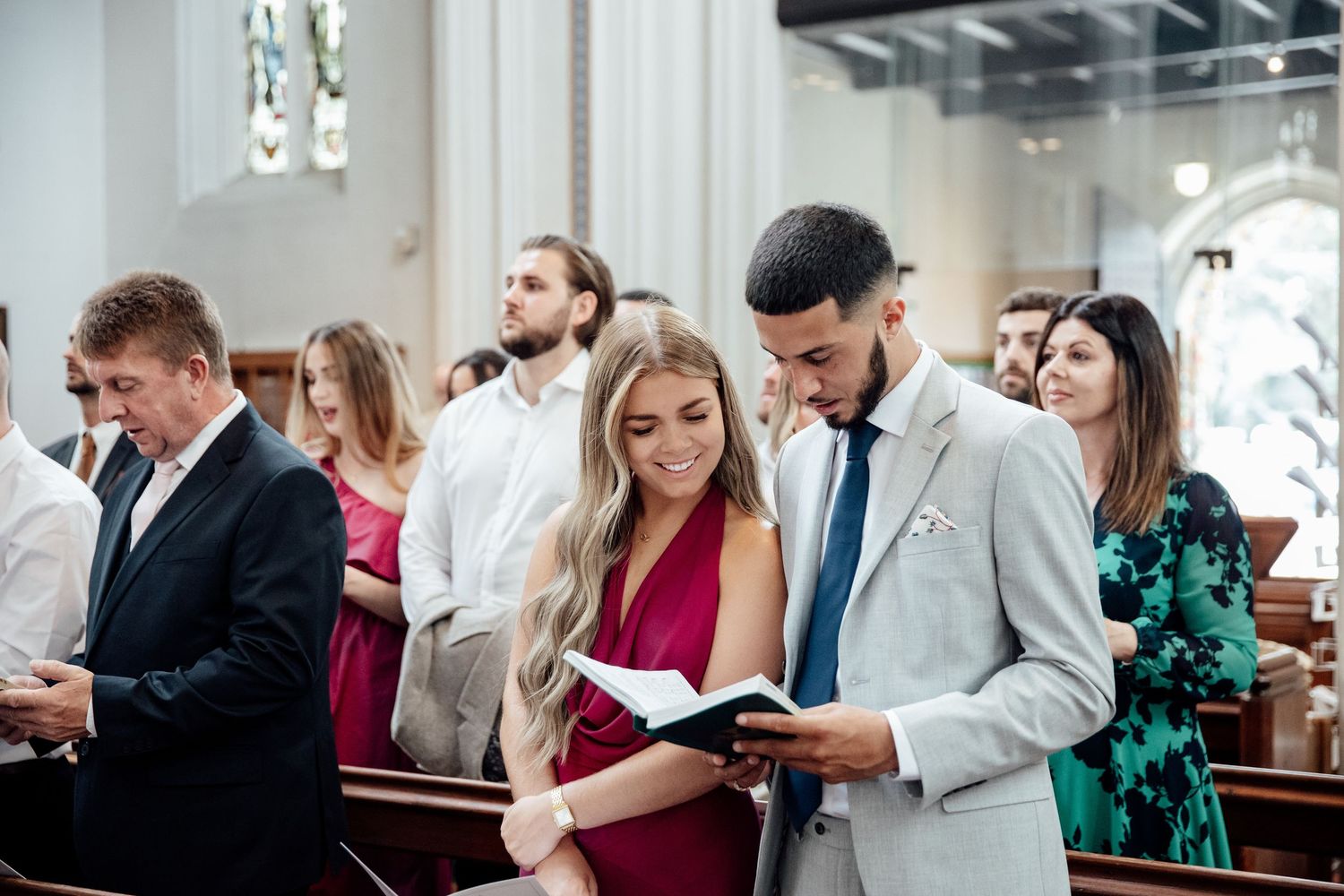 Wedding guests celebrating in a bright indoor venue with elegant decor.