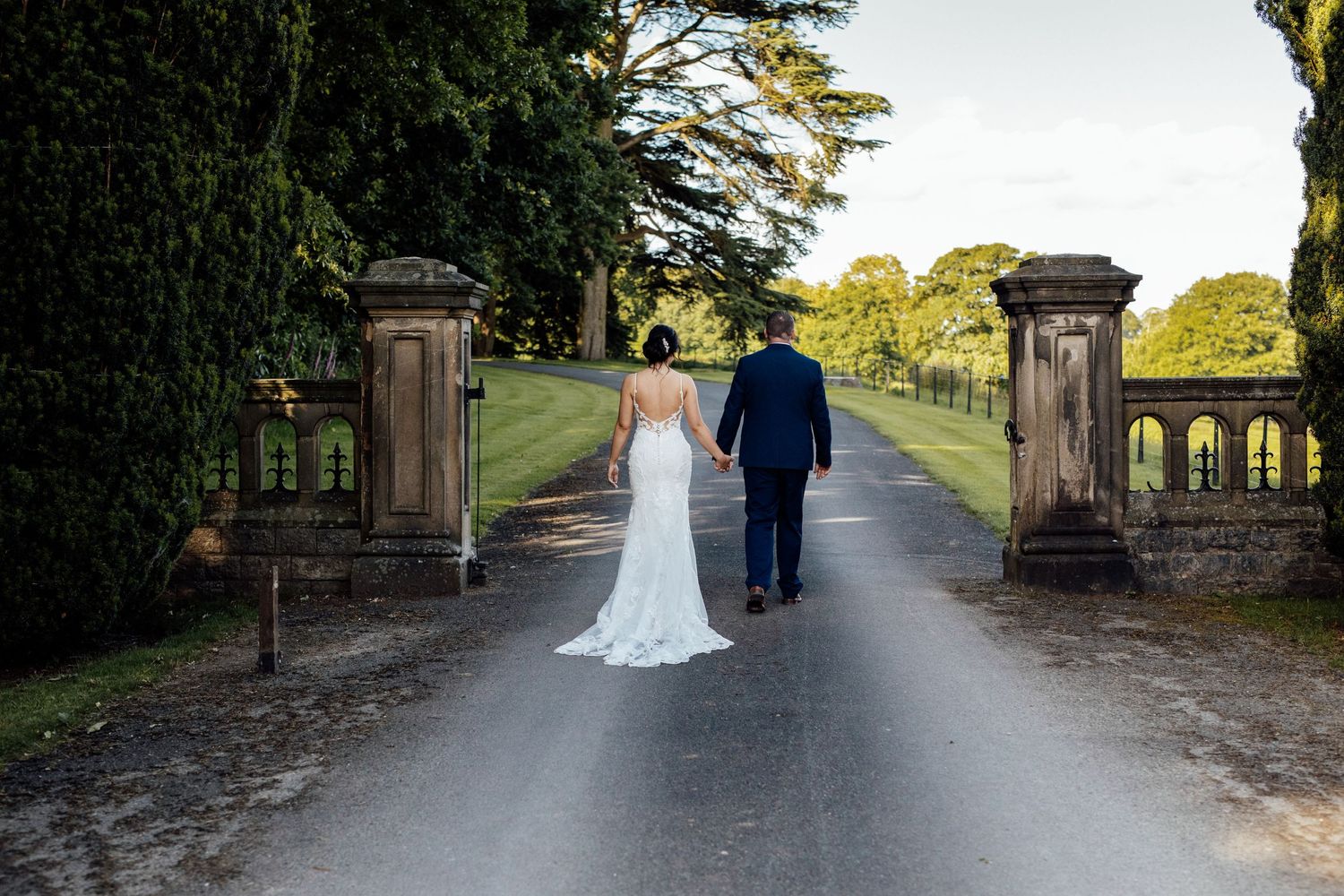 Stone pathway leading through manicured gardens at an elegant wedding venue.