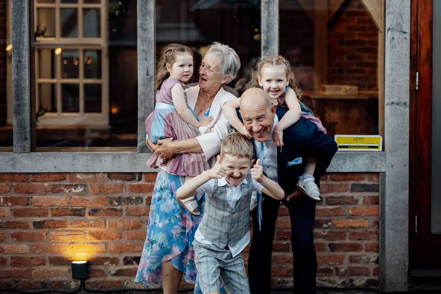 A joyful celebration with guests and children at a rustic brick venue.