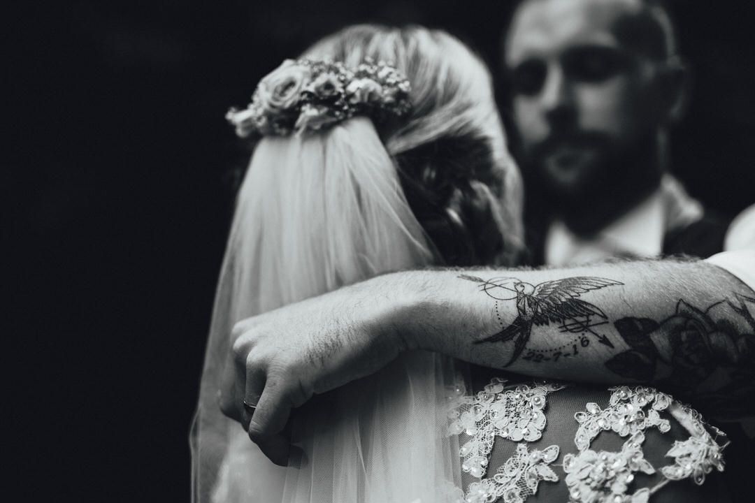 Black and white wedding portrait with dramatic lighting and veil details.