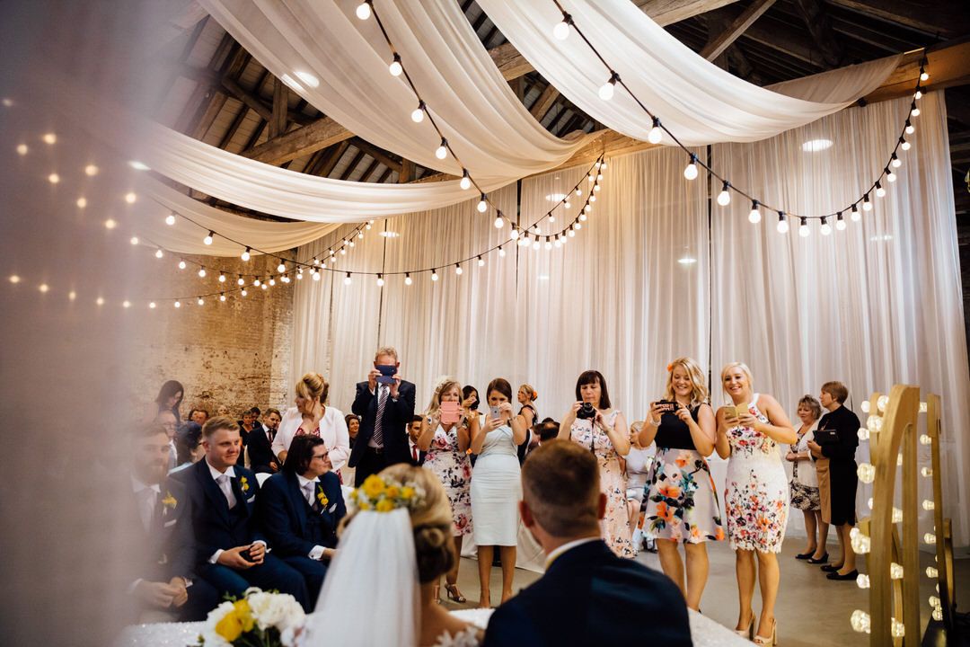 Wedding ceremony venue decorated with white drapes and string lights creating a romantic atmosphere.