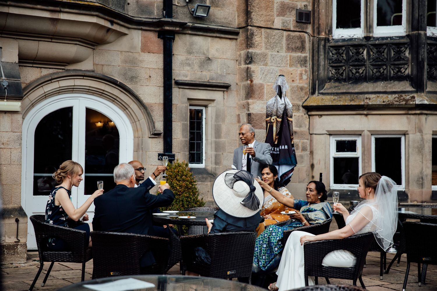 Wedding reception setup outside historic stone building with elegant decor.