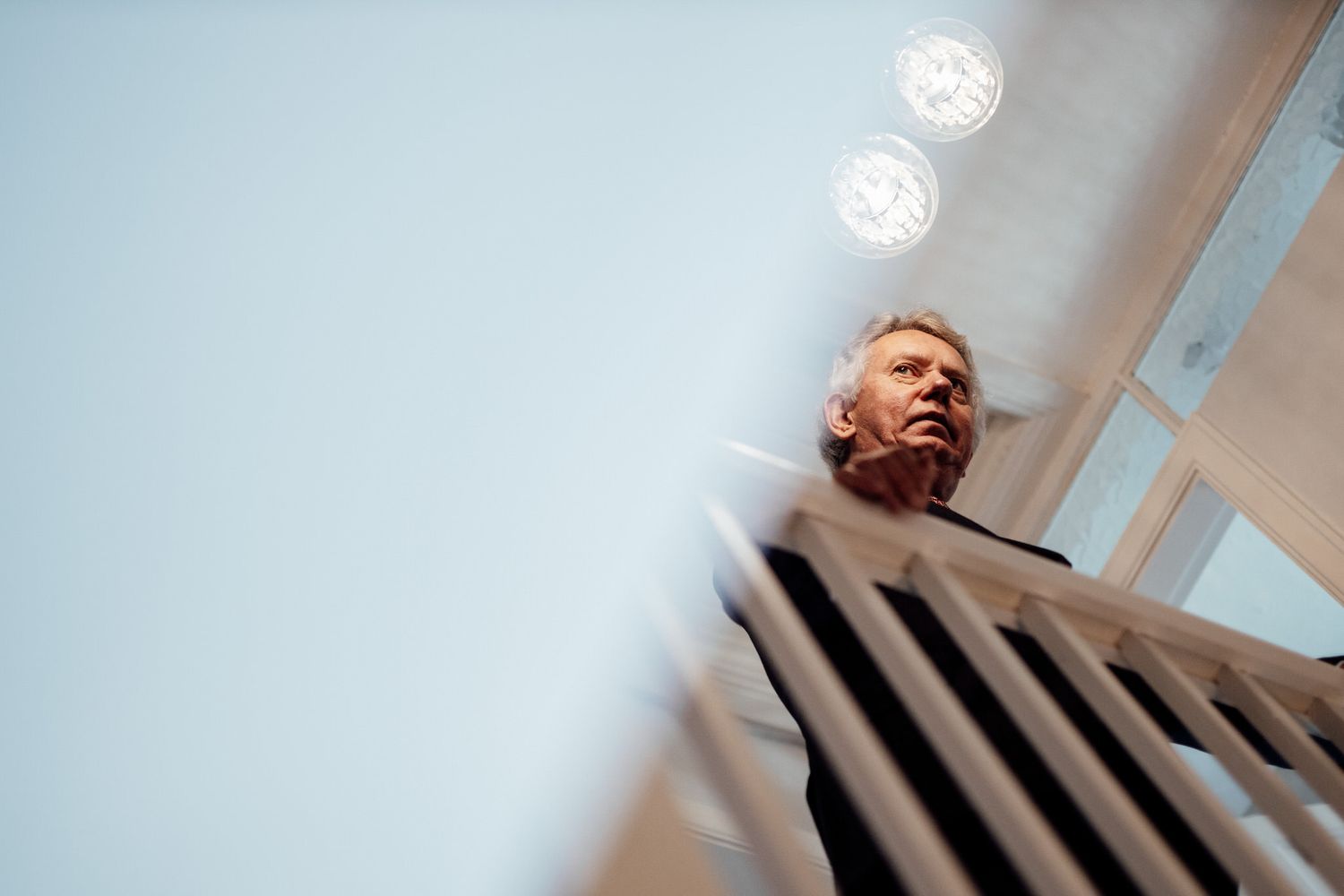 Artistic low angle shot through staircase railings with dramatic lighting.