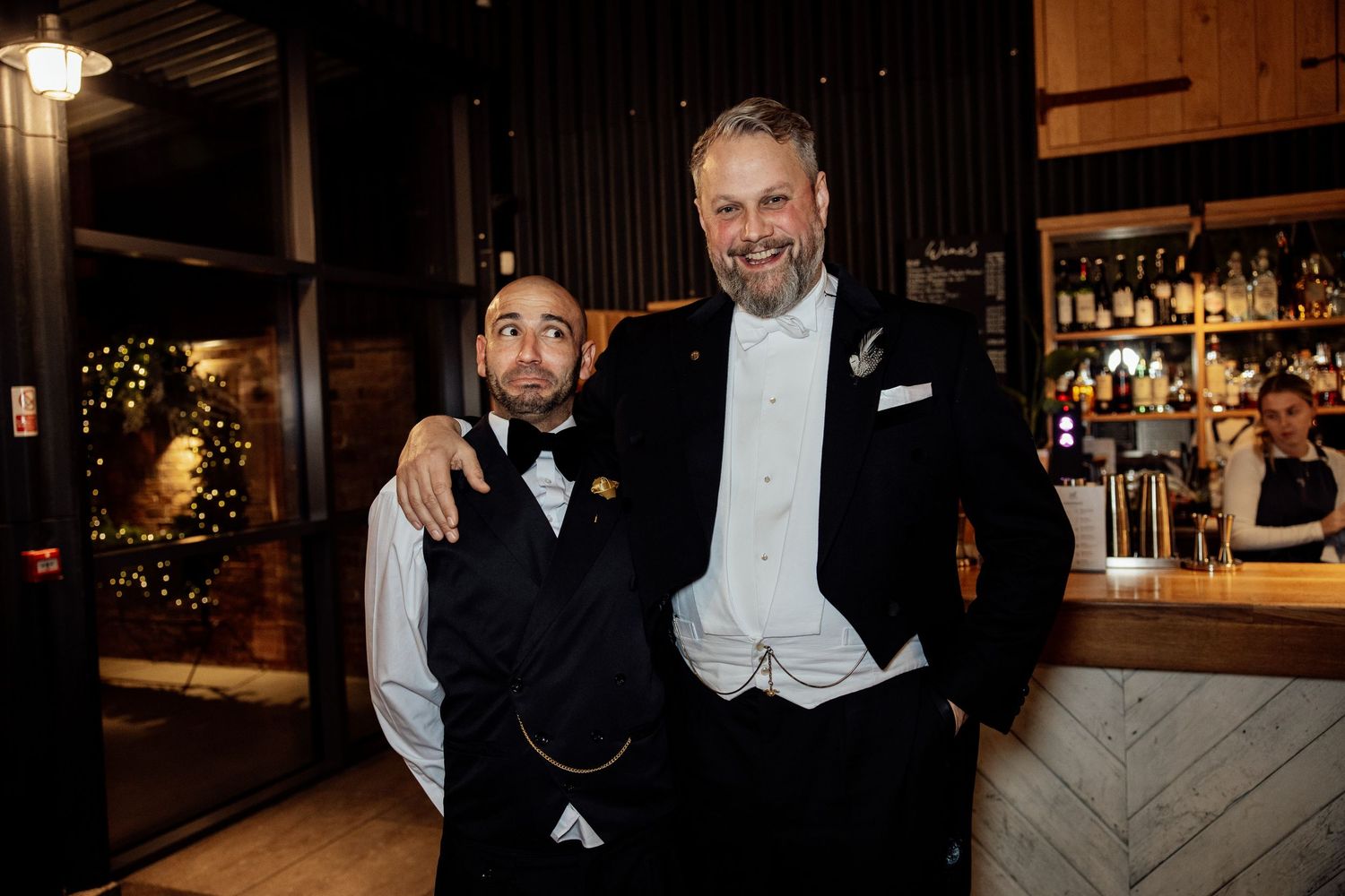 Wedding reception guests enjoying themselves at a modern industrial-style venue.