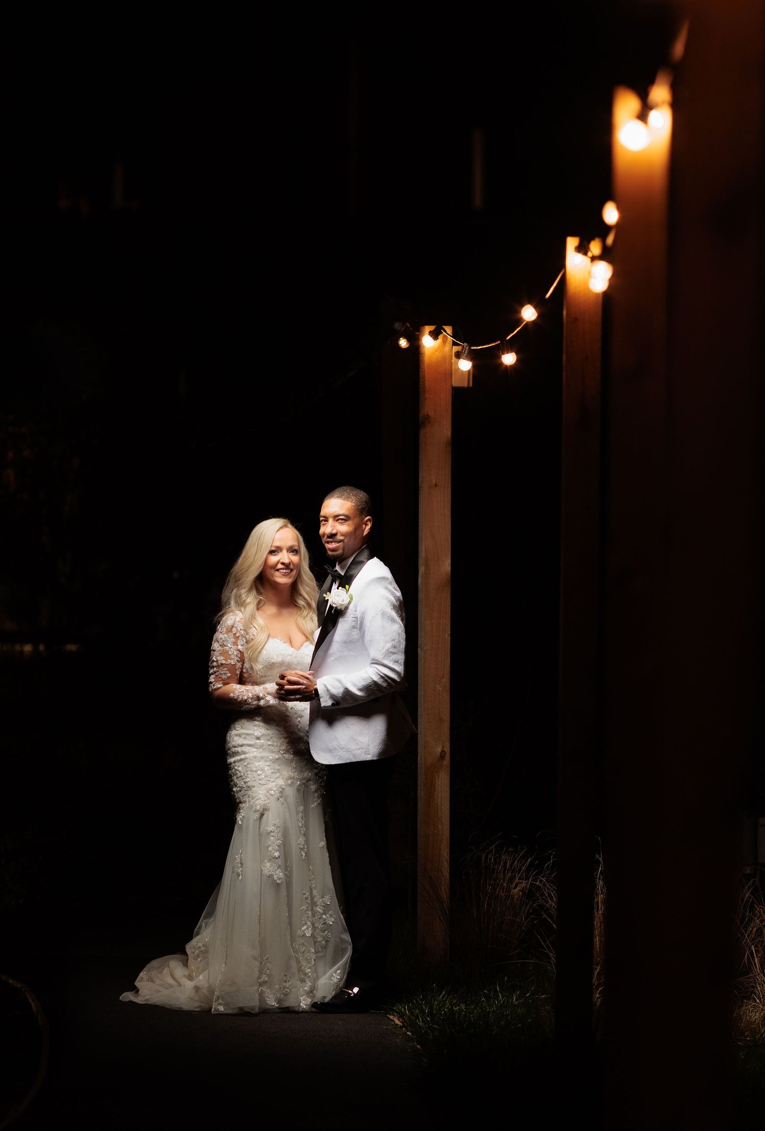 Romantic candlelit wedding portraits show couple embracing in dramatic shadows and glowing light. Whistle Barn Wedding Photography