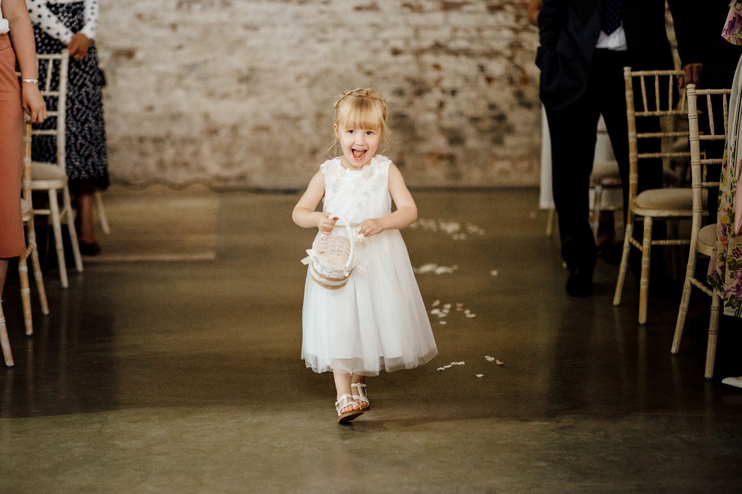 Wedding reception venue with exposed brick walls and white chiavari chairs.