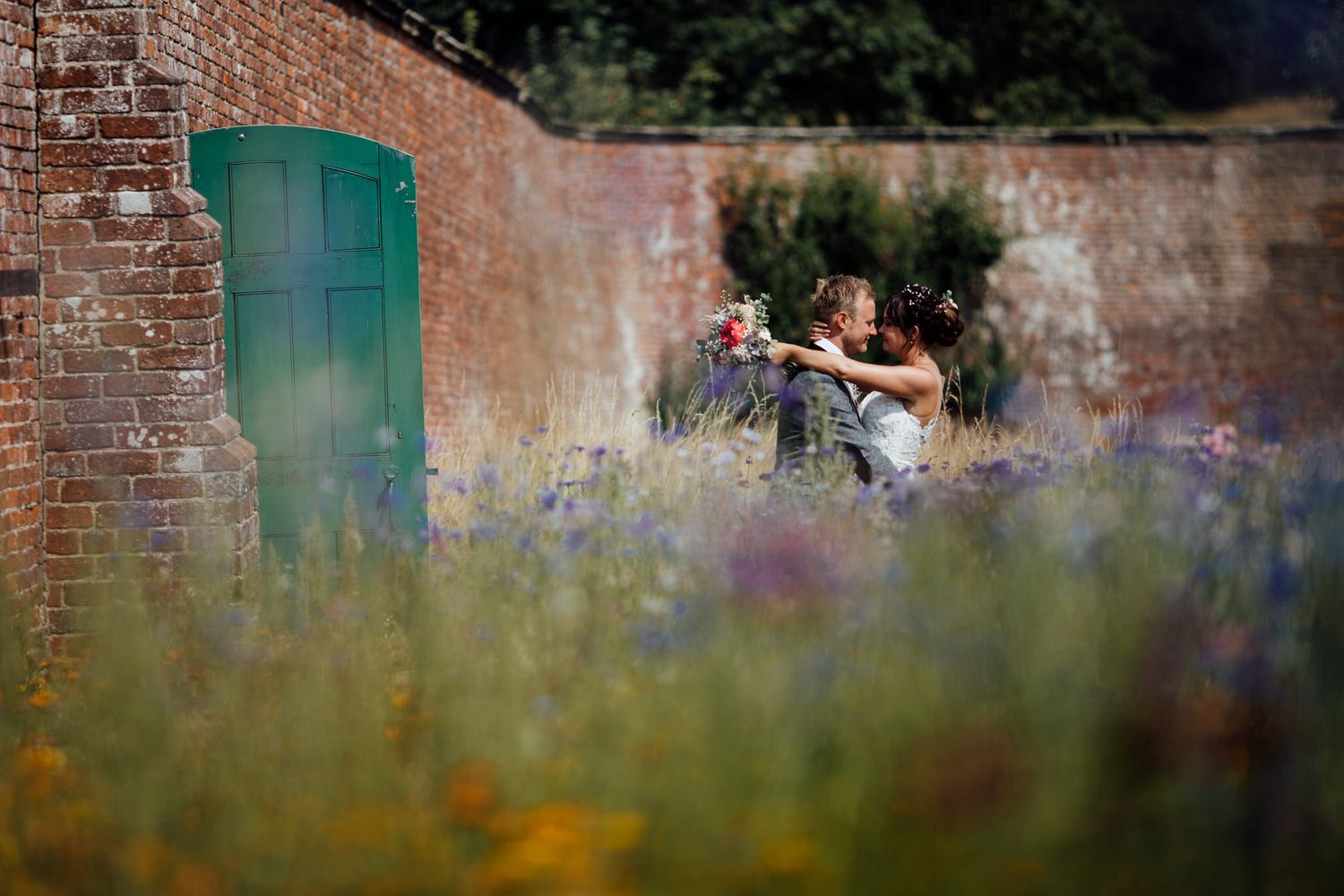 Romantic outdoor garden setting with brick walls and wildflowers for a wedding.