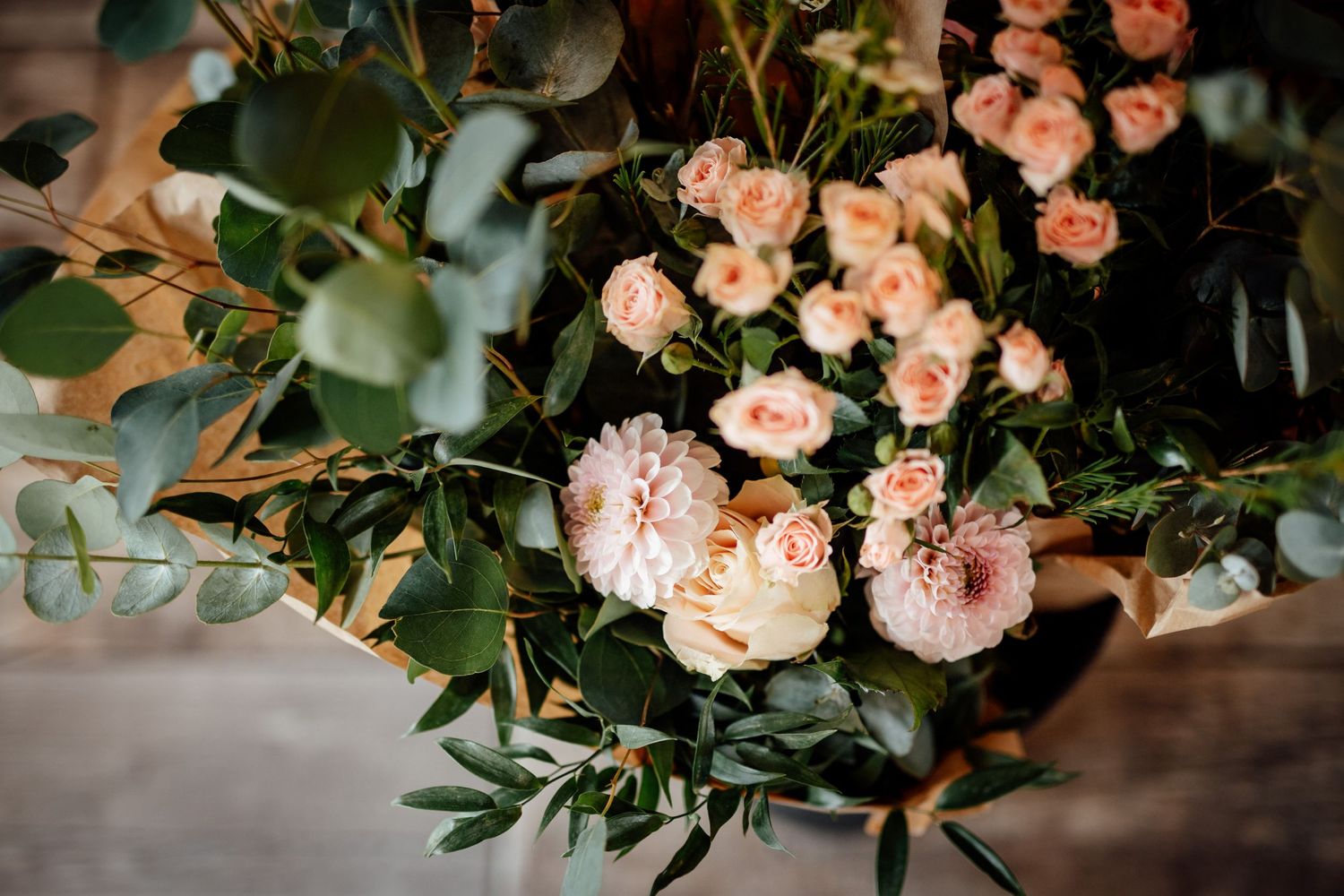 Elegant peach roses and greenery wedding floral arrangement closeup.