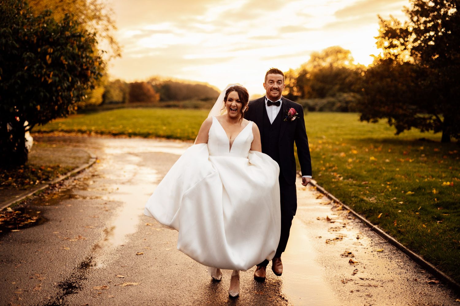 Wedding couple walking along a path during golden hour sunset.